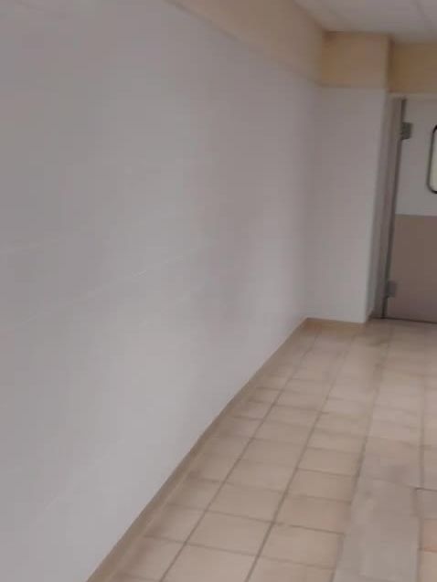 Couloir de service terminé, murs faïencés sur toute la longueur